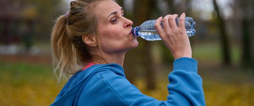 Person drinking water after exercise to support employee wellness and healthy habits